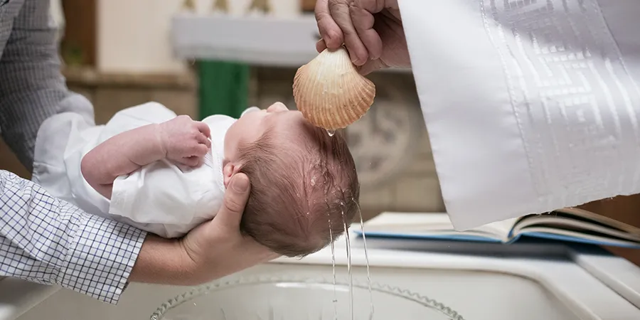 Krupni kadar bebe na krštenju u crkvi. 